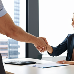 **

A confident business person shaking hands with a hiring manager across a desk in a modern office. The atmosphere is positive and collaborative. In the background, display a subtle graphic representing career growth. Keywords: *Salary negotiation, successful matching, business coach*.

**